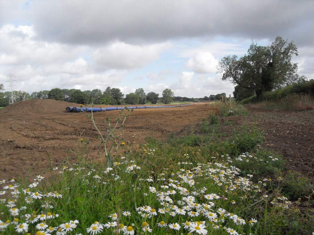 cleared land and blue water pipes prior to laying