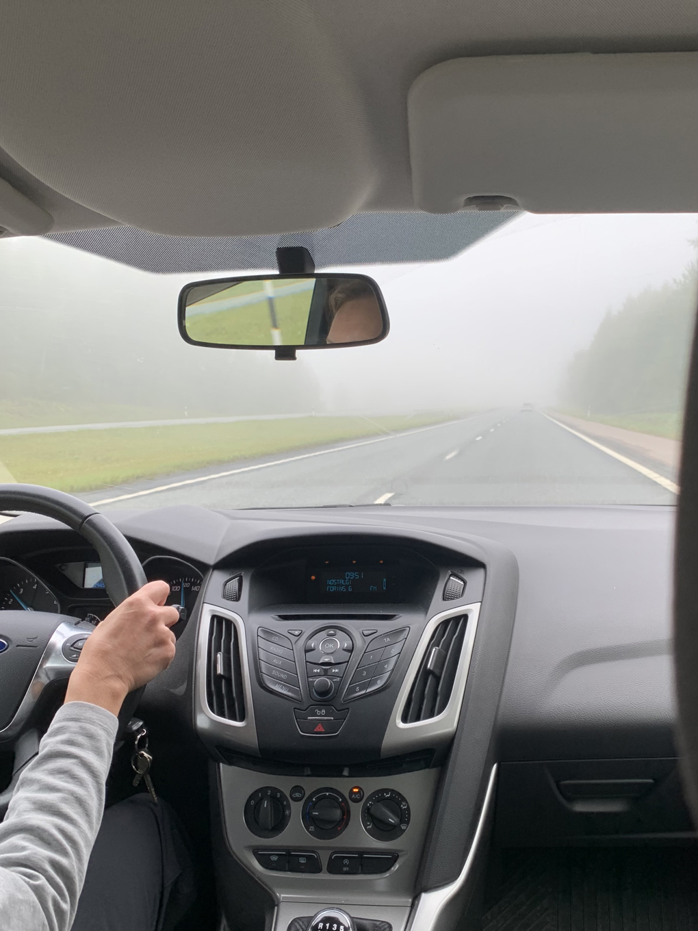 Foggy road as viewed from inside a car.