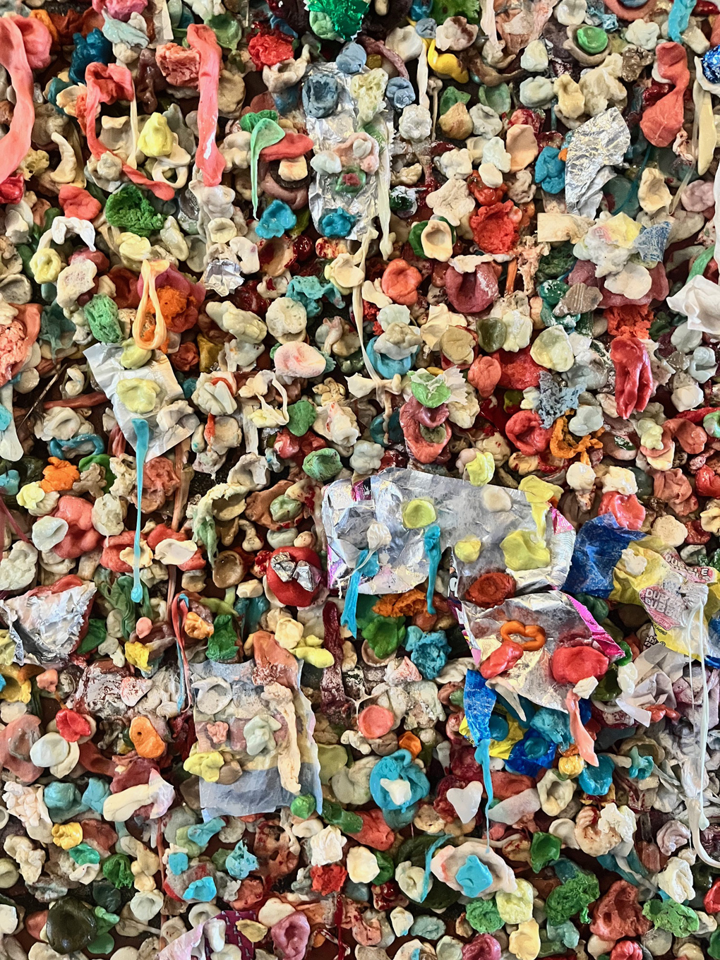 A close up of lots of multi-coloured chewing stuck to a large wall