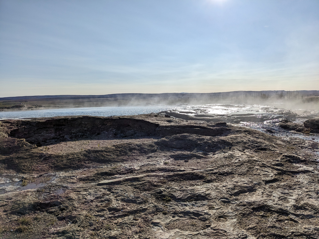 A giant rock pool of steaming water on a sunny autumn day