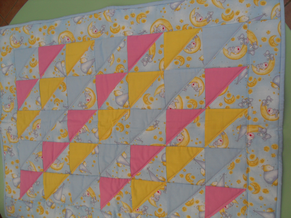 A blue, pink and yellow baby quilt.
