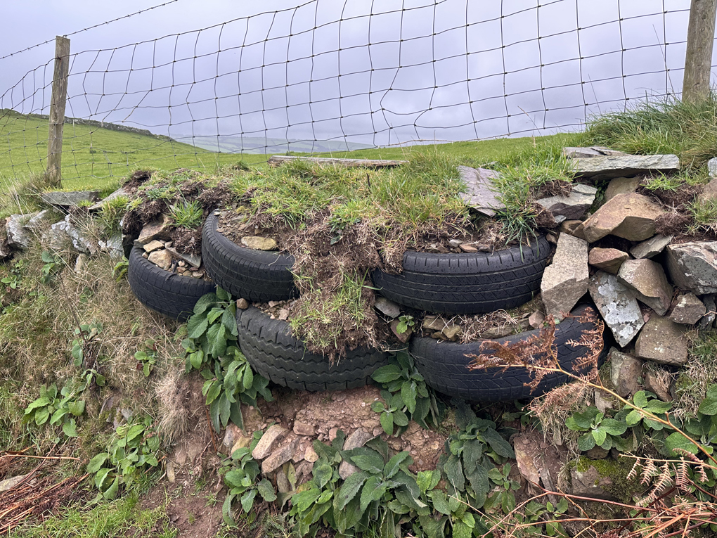 A dry stone wall partially composed of used rubber tyres