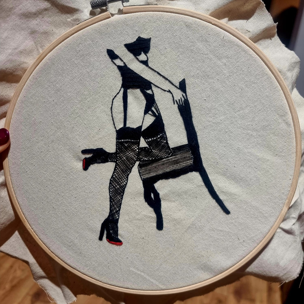 Sewing of a lady in suspenders kneeling on a chair