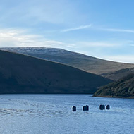 Looking over the waters of Meldon Reservoir on a clear day, with Dartmoor in the background