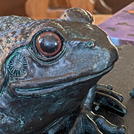 Two frog ornaments on a spinning cake stand.