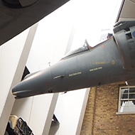 Harrier Jet and Spitfire plane hanging from the ceiling of the IWM looking up to the roof