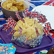 Table covered in coronation-themed food with a Union Jack tablecloth