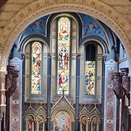 Bar in an old church with font, vaulted ceiling, stained glass window