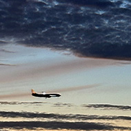 Sunset with dark cloud bands. Bright shining planet Venus top of frame and a plane flying across at the bottom.