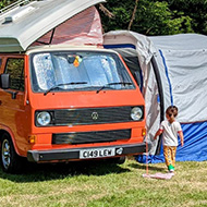 Campsite with campervan and kids wandering around