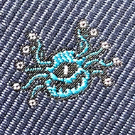 A blue tie with lots of tiny embroidered d20s and beholders