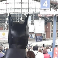 Batman walking down a train platform