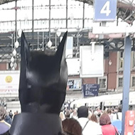 Batman walking down a train platform