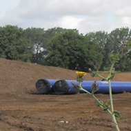 cleared land and blue water pipes prior to laying