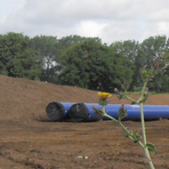 cleared land and blue water pipes prior to laying
