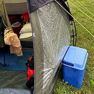 We see a medium sized tent pitched on a  New Wine village at the Kent County Showground