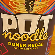 A doner kebab flavour pot noodle awaiting hot water from the recently-boiled kettle behind