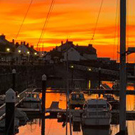 Brilliant red and gold sunset over a quay