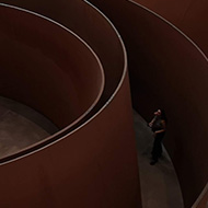 Large steel curved structures shown from above with people wandering amongst them.