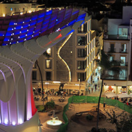 View from Las Setas in Seville at nighttime looking across the city, where the wooden strucutre of Las Setas itself is illuminated blue