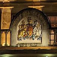 The Theatre Royal at night in the rain with lights shining different colours reflecting in the water