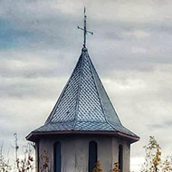 Church behind trees with new building construction in front during Autumn