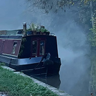 Muddy tow path and autumnal trees next to a canal