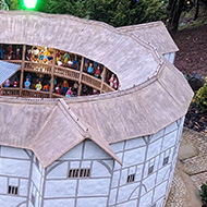 Model village featuring The Globe theatre in foreground, a golf course (with model players) behind and a miniature, replica 19th century crescent behind that.