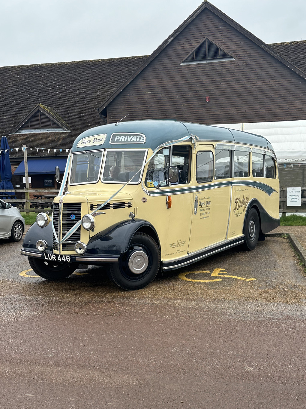 We see a 3/4 view of a restored 1950s Bedford coach