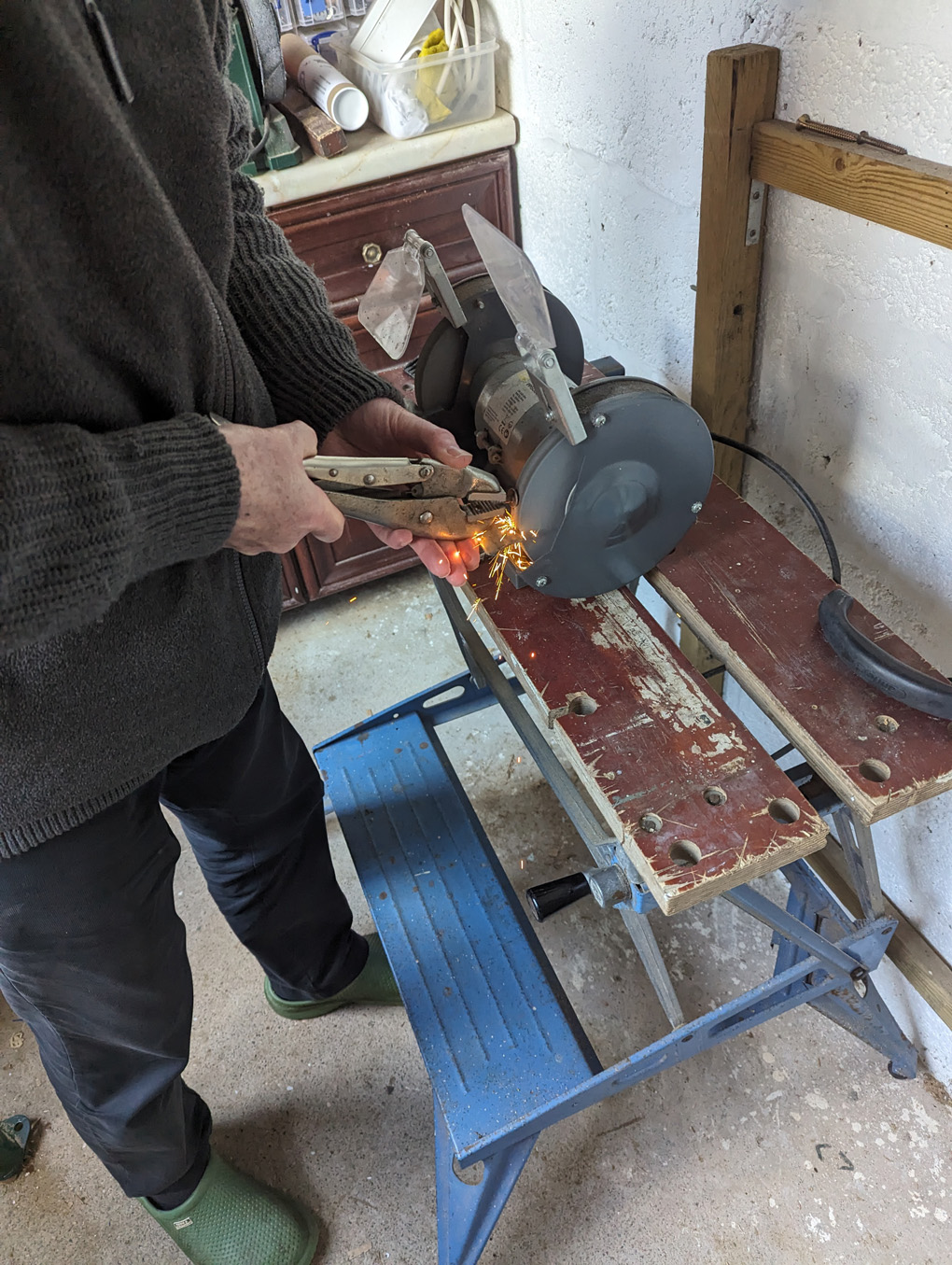 Man standing at a grinder with sparks flying