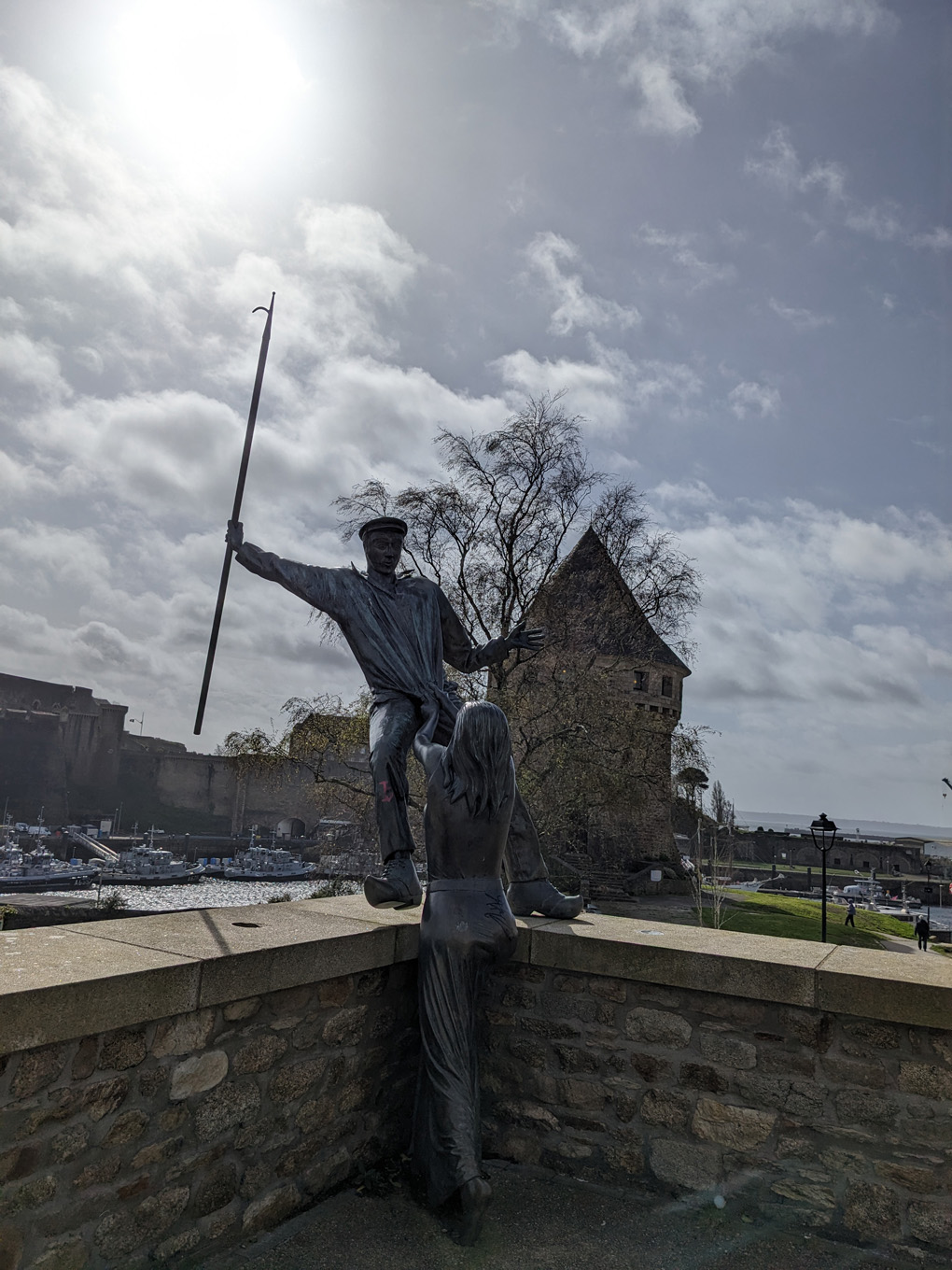 A statue of a person falling and another reaching to grab them