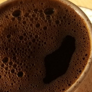 Four coffee cups with frothy cartoon faces