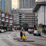 A grey day walking through Barbican past the colonnade of shops with tower blocks above