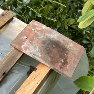 A tile attached to a wooden framed roof