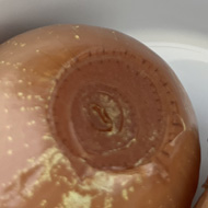A close up of two discoloured pickled onions in a small white bowl