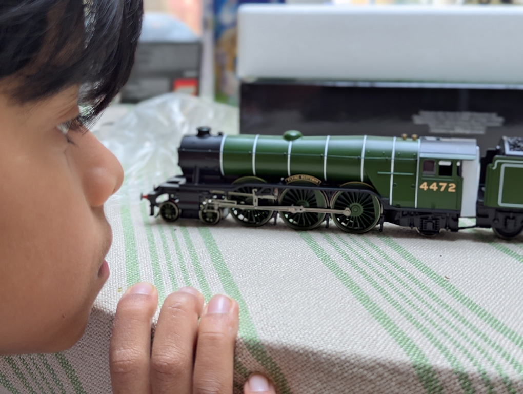 Picture if child looking at a Hornby Flying Scotsman model on a table