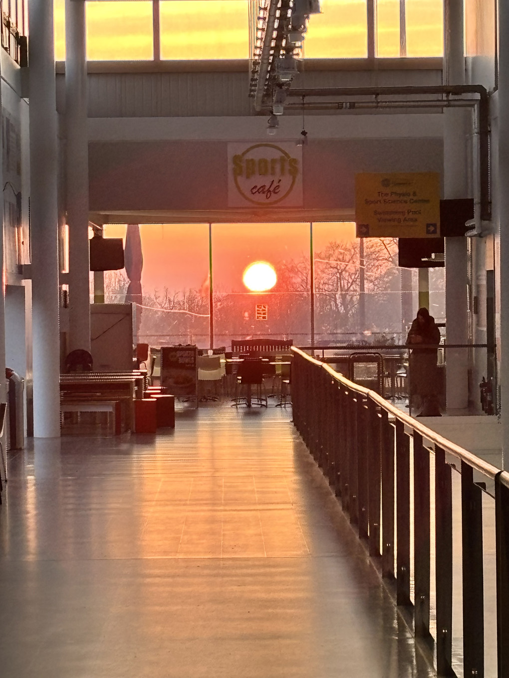 A large red sun is framed at the end of a long corridor. The sunlight has tinted everything red and orange.