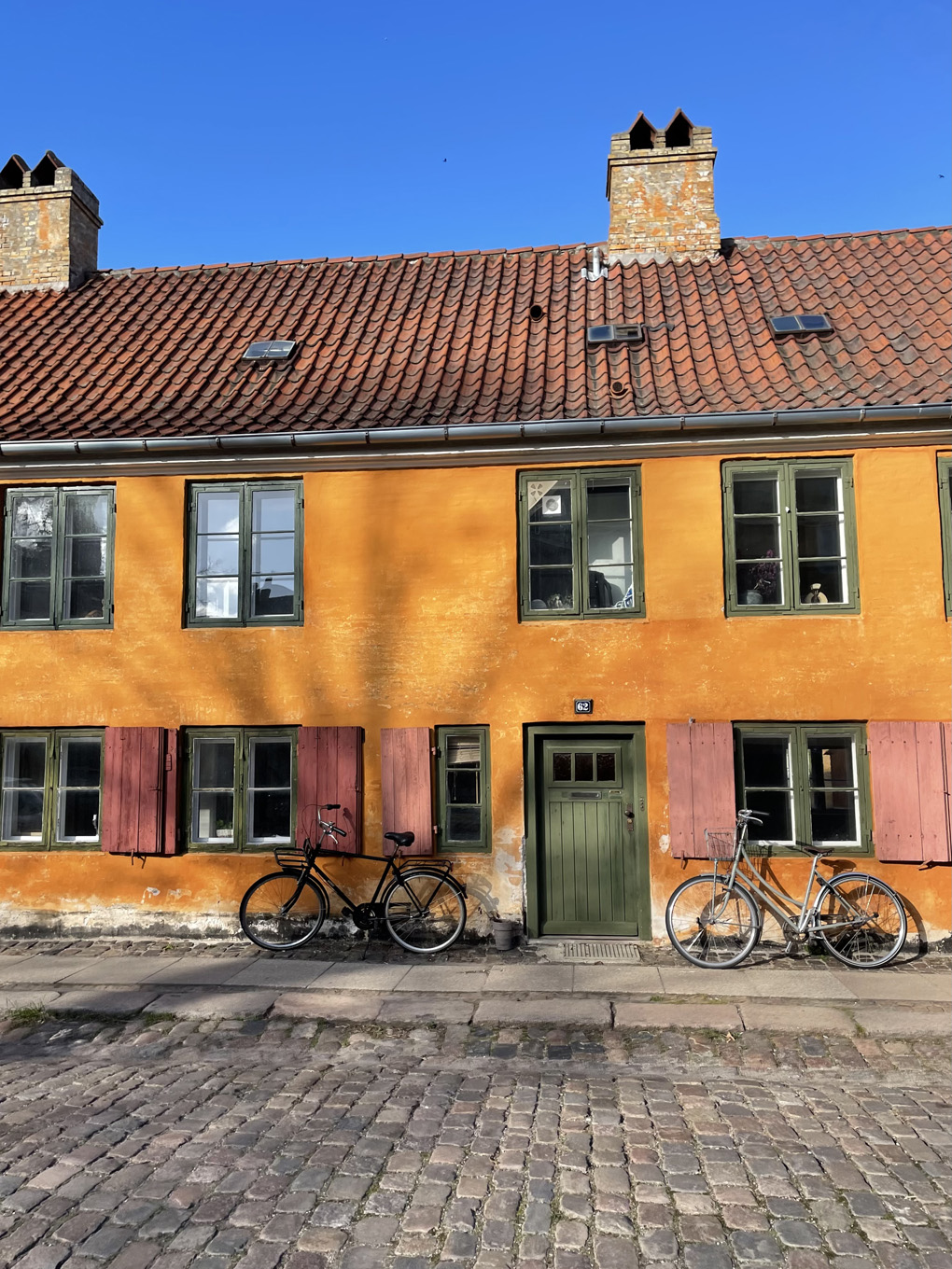 Yellow building with bikes on the side.