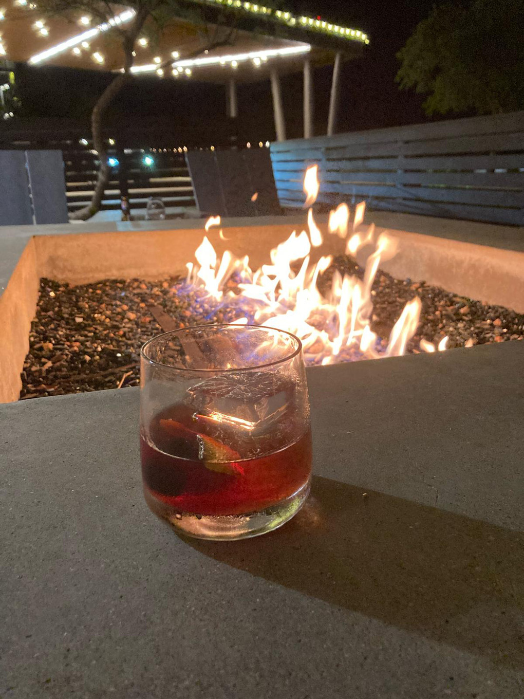Drink on a table overlooking a fire pit
