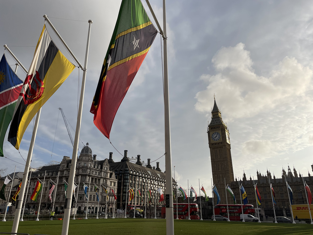 Parliament square surrounded by flags on the Commonwealth with Big Ben in the background