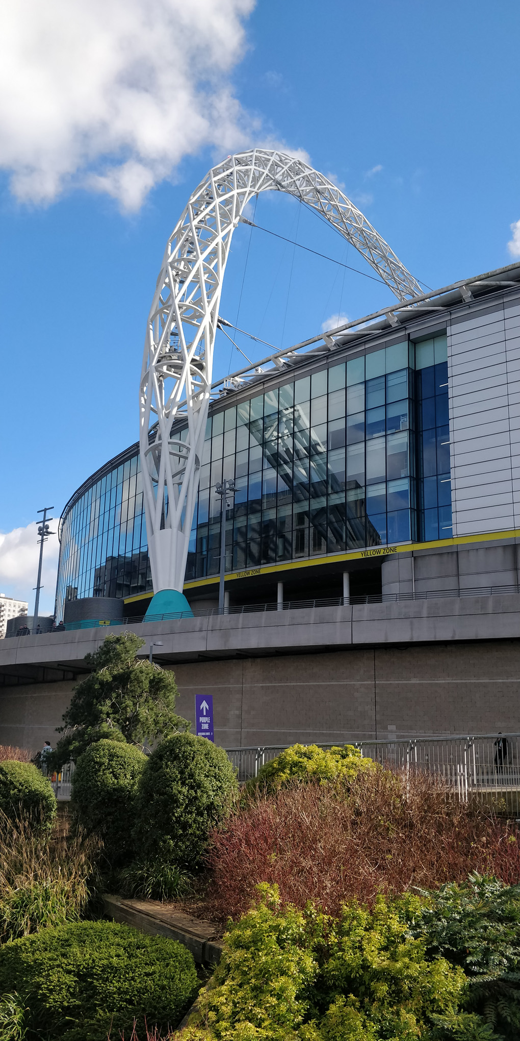 Wembley stadium and arch, under a blue sky.