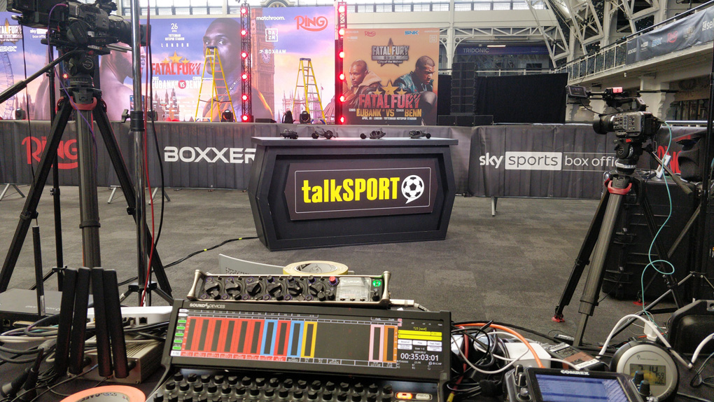 Audio and cameras with talkSPORT presentation desk, in front of stage set for Eubank/Benn boxing weigh-in media event.