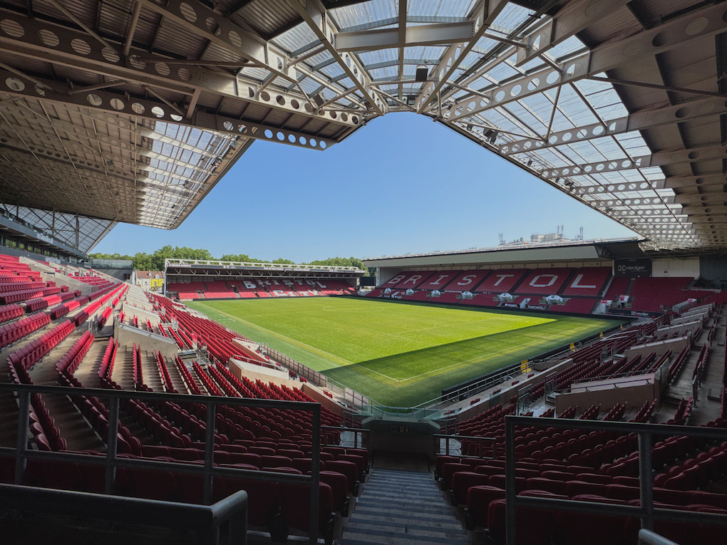 An empty Bristol City football stadium, with red and white seating spelling out the name of the club