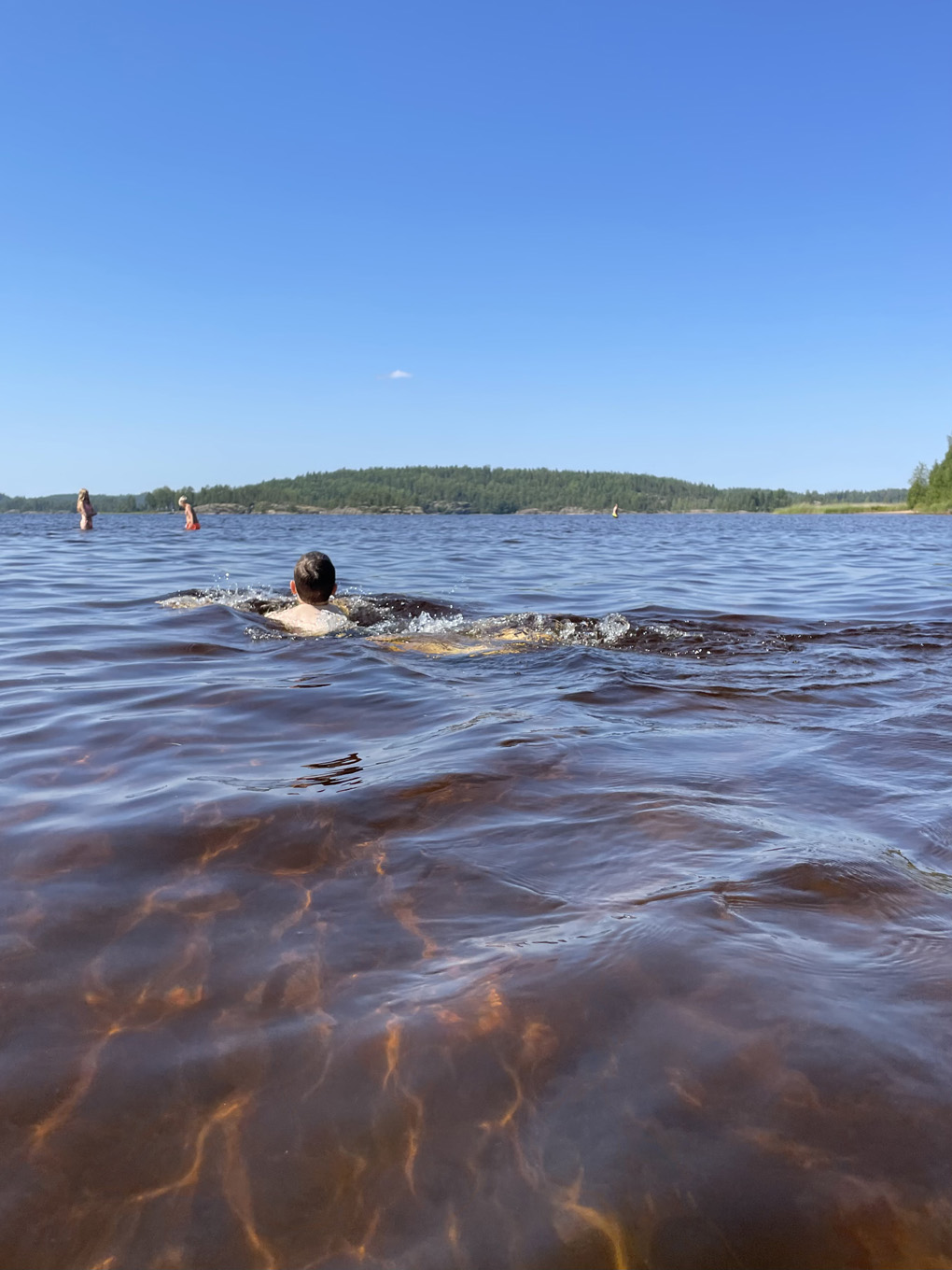 A person swimming away from the camera.