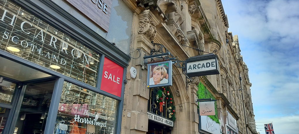North Bridge Road in Edinburgh, pointing above the entrance to North Bridge Arcade - a grand Edwardian/Victorian building. A sign says 