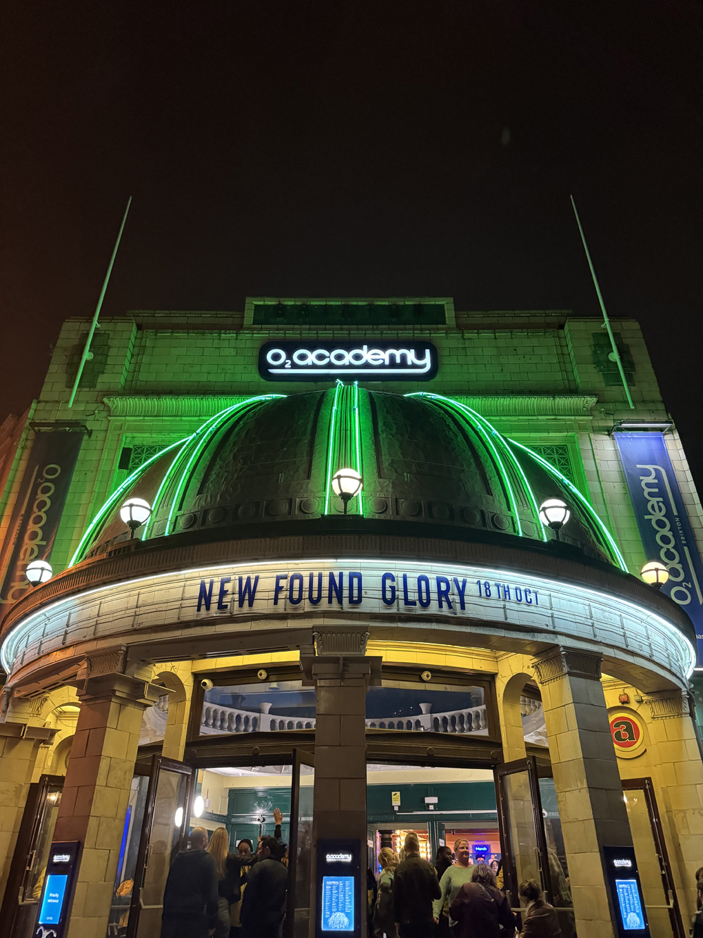 Front of Brixton academy lit up at night with new found glory on the marquee