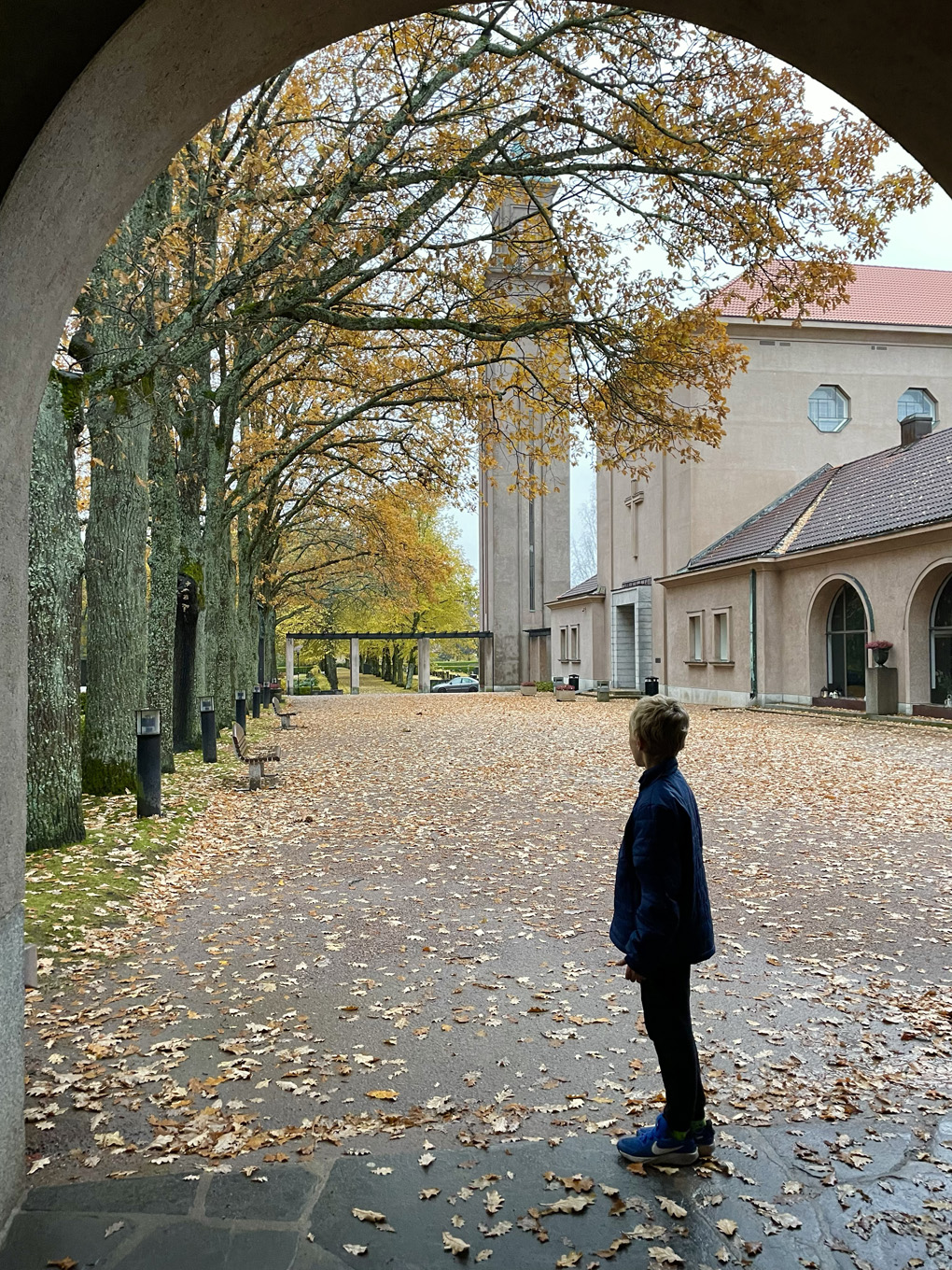 A silhouette of a boy under archway.