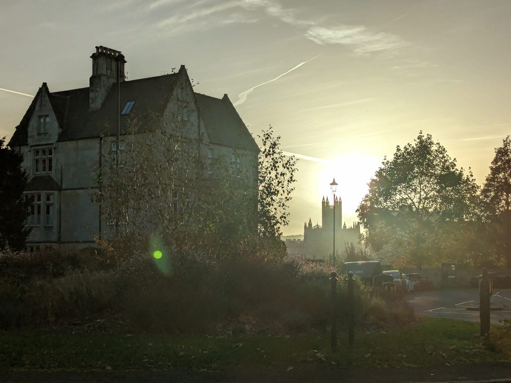 Sun setting silhouetting a church in Bath