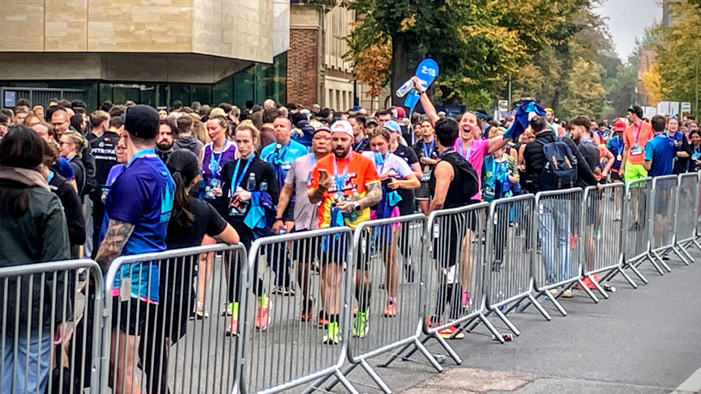Photo of my wife in a huge crowd having just finished the Oxford half marathon in a personal best time, hands in the air with a look of elation on her face, having finally finished months of training!