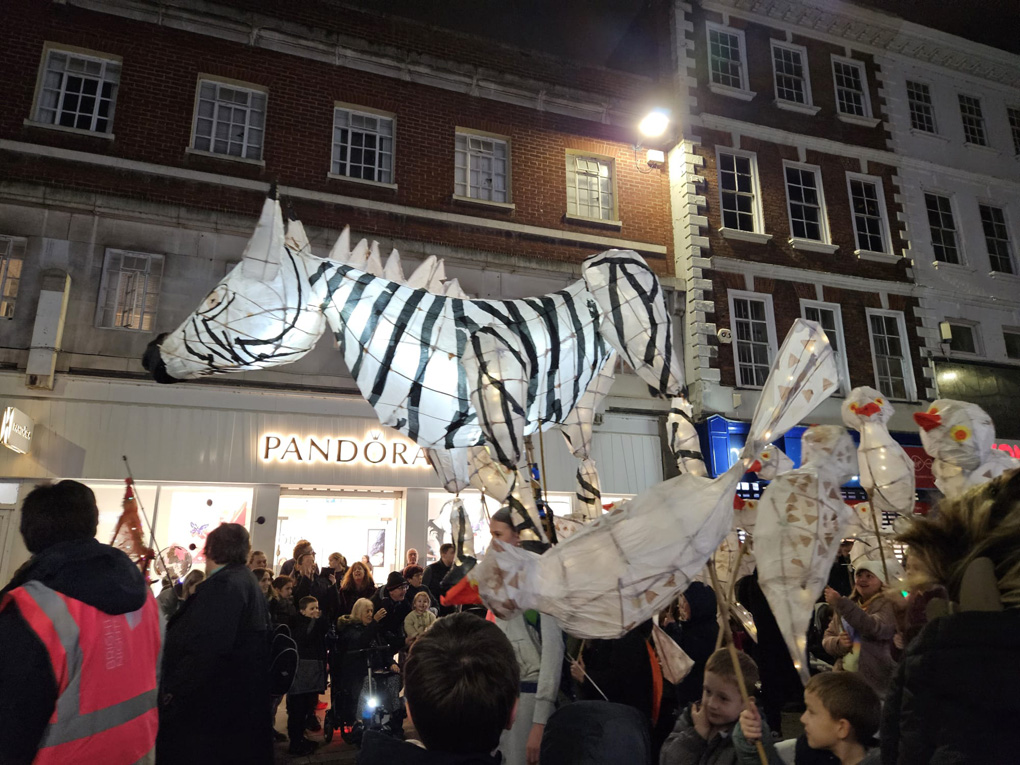 Large lantern in shape of zebra being carried through town